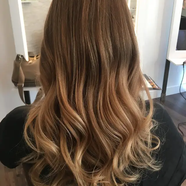 Honig-Balayage mit Locken — Warme helle Bänder in schwungvollen Längen