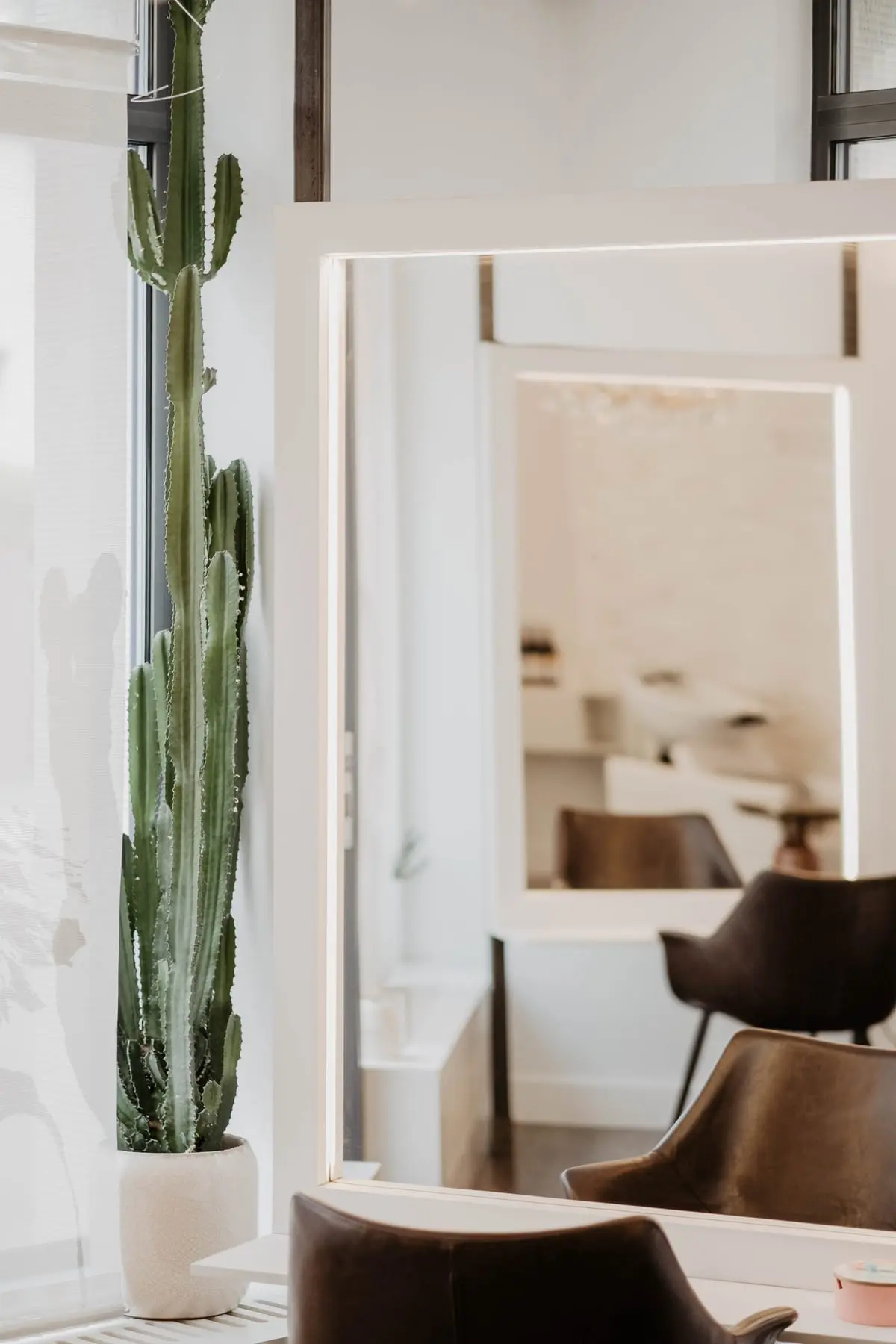 Styling-Platz im Studio von Valesca Hair mit beleuchtetem Spiegel und Kaktus am Fenster