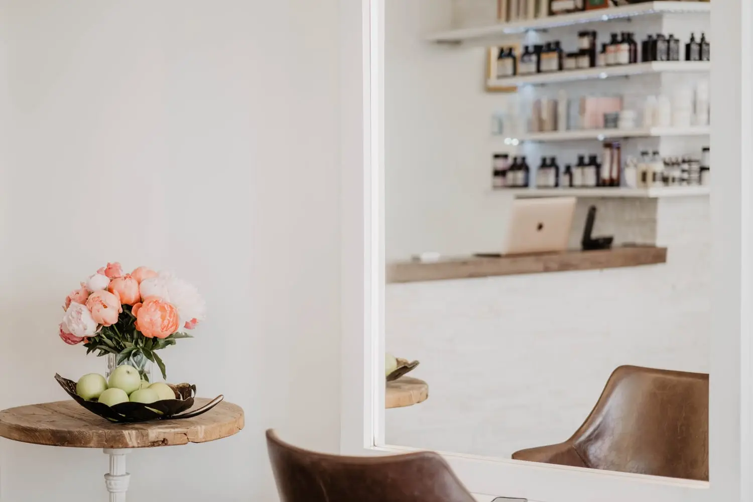 Heller Salonbereich im Studio von Valesca Hair mit Blumen und Produktregal